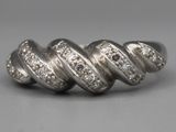 une image représentant une bague en diamant posée sur une surface grise