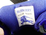 someone is holding a blue shoe with a burberry label on it
