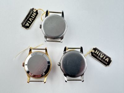 trois montres sont assises l'une à côté de l'autre sur une surface blanche
