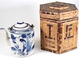 une théière bleue et blanche à côté d'une boîte en bois
