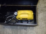 un compresseur d'air jaune logé dans un boîtier noir