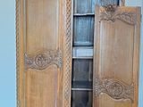 a wooden armoire with a door open on a hard wood floor