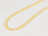 a close up of a necklace on a white surface with a white background