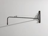 une photo en noir et blanc d'une lampe murale accrochée à un mur blanc
