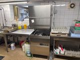 une grande cuisine en inox équipée d'un évier et d'un lave-vaisselle
