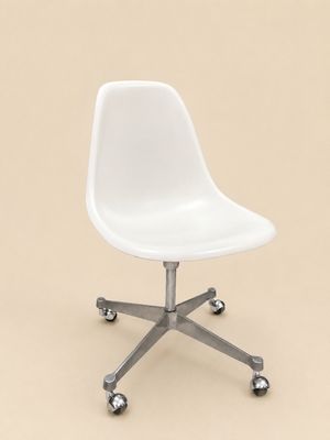 a white chair with wheels on a beige background