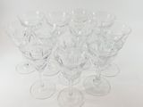 six clear wine glasses sitting on top of each other on a white surface