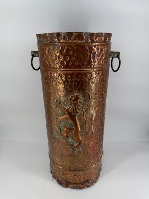brass vase with a lion on the side of it on a white background