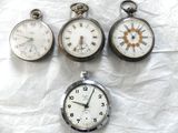 Plusieurs types d'horloges sont exposés sur une surface blanche