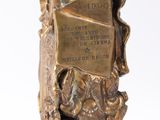 bronze sculpture of a bookend with a book on top of a pile of books