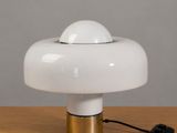 une lampe de table blanche posée sur une table en bois