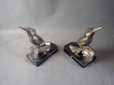 pair of silver bird figurines on black marble bases