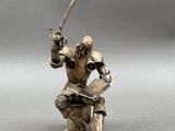 statue of a man in armor holding a sword and a book