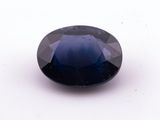 a close up of a blue sapphire stone on a white surface