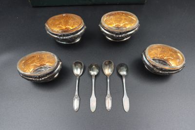 four silver spoons and four silver bowls with spoons on a table