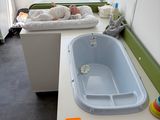 un bébé allongé dans une baignoire, dans une petite pièce