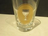 a shot glass sitting on a table with a shadow on the table