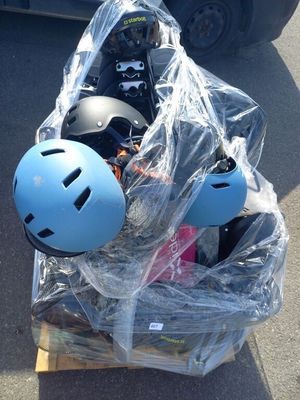 une caisse remplie de casques et un casque posé sur une palette