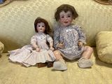 two dolls that are sitting on a couch together