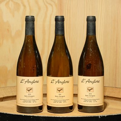 three bottles of wine sitting on top of a wooden barrel
