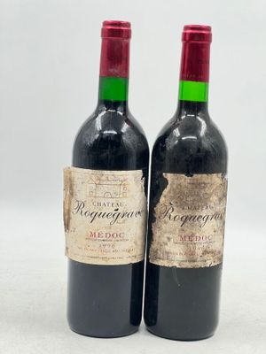 deux bouteilles de vin rouge posées l'une à côté de l'autre sur une surface blanche
