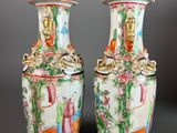 pair of chinese vases with floral designs on them on a gray background