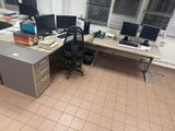 a desk with two computer monitors on it in an office