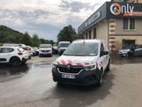 des voitures garées devant un immeuble sur la façade duquel est accrochée une pancarte
