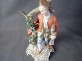 a figurine of a man sitting on a tree branch