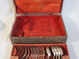 a wooden case with silverware in it on a white surface