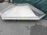 a metal tray on the ground next to a tarp