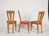 two wooden chairs sitting next to each other on a white surface