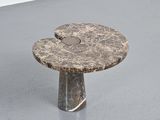 a small table with a stone top on a gray floor