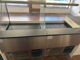 stainless steel counter top with glass display cases in a commercial kitchen