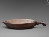 an old wooden bowl with a handle on a gray background