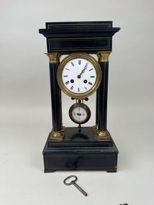 une horloge posée sur une table à côté d'une clé