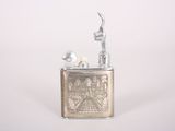 a silver lighter that is sitting on a white surface