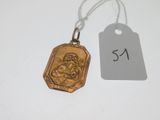 une petite médaille en or sur laquelle est représentée une femme