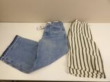 two pairs of jeans sitting on top of a table next to each other