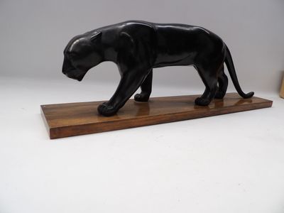 statue d'une panthère noire posée sur un socle en bois