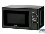 un four à micro-ondes noir posé sur une table blanche
