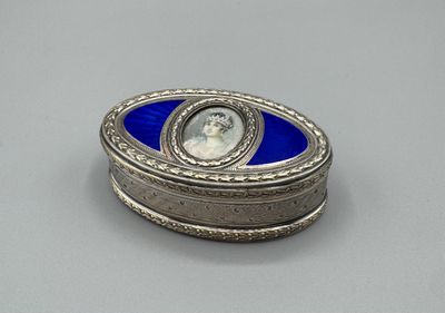 une image représentant une boîte argentée et bleue sur laquelle figure le portrait d'une femme