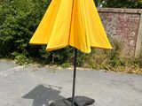 a yellow umbrella sitting on top of a metal pole