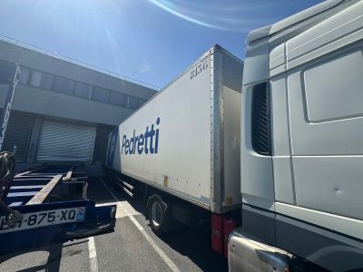 un camion garé sur un parking à côté d'un immeuble