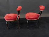 two red chairs with black legs and a red cushion