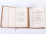 an open book sitting on top of a table next to a white wall