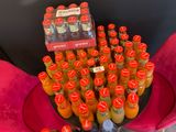 many bottles of orange juice sitting on a pink chair