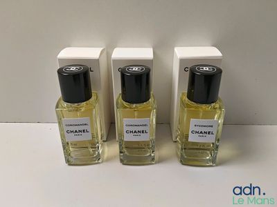 trois flacons de parfum Chanel posés sur une table