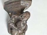 a statue of a man holding a book on a wall