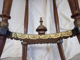 a close up of a wooden chair with a gold decoration on it